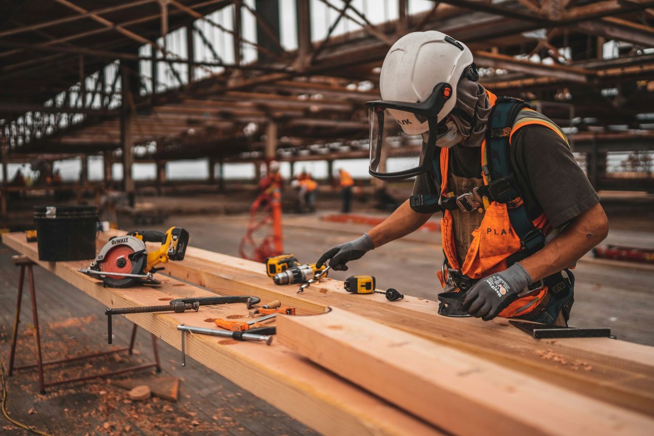 Tradesperson in safety gear working on timber with power tools