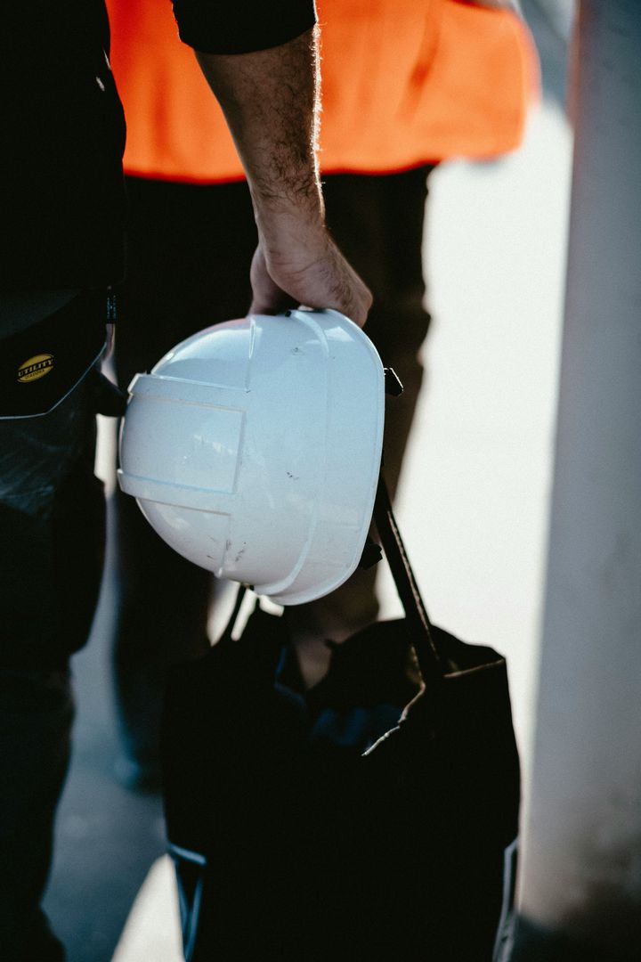 Tradesperson holding a white hard hat